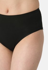 Slip bikini nero a vita alta realizzato in tessuto morbido. Presenta un taglio classico con una vita elastica e cuciture minime.