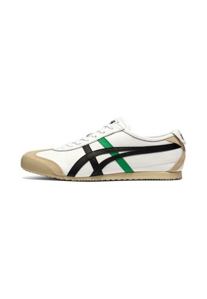 Niedriger weißer Sneaker mit schwarzen und grünen seitlichen Streifen, beige Zehenkappe und Sohle sowie weißen Schnürsenkeln, gezeigt in der rechten Seitenansicht.