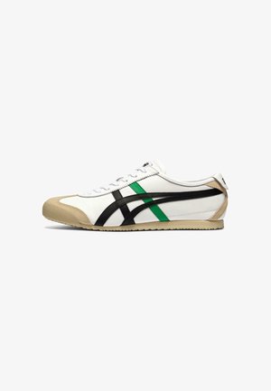 Scarpa da ginnastica bianca a profilo basso con strisce laterali nere e verdi, punta e suola beige e lacci bianchi, vista lato destro.