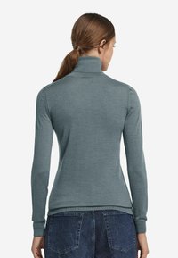 Grauer, langärmeliger Rollkragenoberteil mit taillierter Passform und gerippten Bündchen. Das Material wirkt weich mit einer glatten Oberfläche. Die Rückansicht zeigt eine maßgeschneiderte Passform.