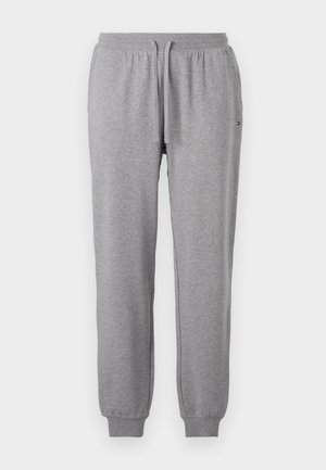 šedé bavlnené jogger nohavice s elastickým pásom, šnúrkovým zapínaním a pletenými manžetami. Na ľavej strane sa nachádza malé logo.