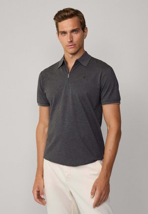 Short-sleeve, dark gray polo shirt with a zippered collar and subtle logo. Soft fabric with a smooth texture and tailored fit.