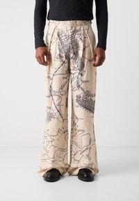 Beige wide-leg trousers with a map print in dark blue. Features pleats at the waist and a lightweight, textured fabric.