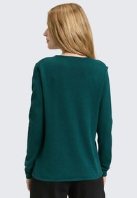 Groene trui met lange mouwen, een ronde halslijn en geribbelde zoom, met een gladde textuur en een losse pasvorm, gezien vanaf de achterkant.