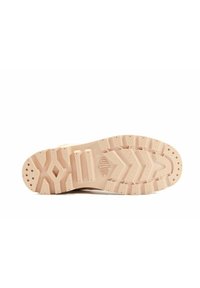 Podeszwa buta, wykonana z jasnego beżowego materiału gumowego, teksturowana w zygzakowate i kropkowane wzory dla lepszej przyczepności i gripu.