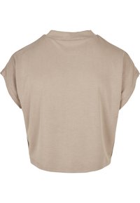 Tricou bej scurt, cu mâneci scurte, textură moale și decolteu rotund. Design minimalist, fără modele sau accesorii vizibile.