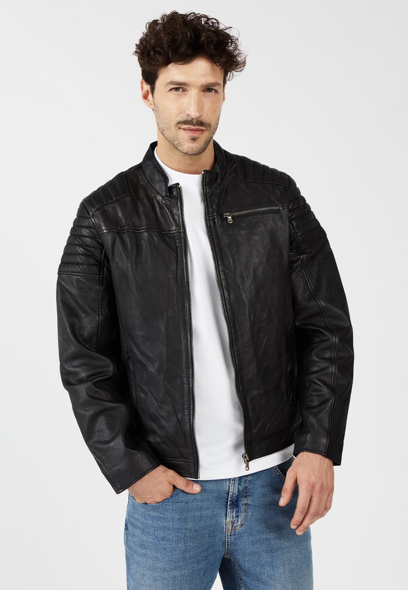 Zwarte leren motorjacket met doorgestikte schouderaccenten en een ritszak. Heeft een opstaande kraag en aansluitende manchetten.