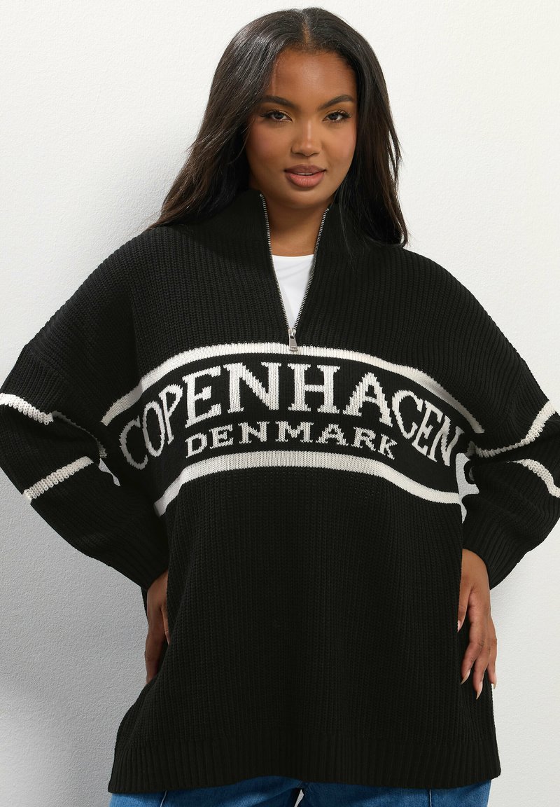 Pull en tricot noir avec un col zippé, arborant "COPENHAGUE DANEMARK" en lettres blanches sur le devant. Coupe ample avec des poignets côtelés.