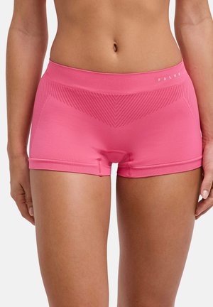 Nahaufnahme einer Person, die pinke nahtlose, enganliegende Shorts mit gemustertem Detail und dem Markennamen "FALKE" am Bund trägt.
