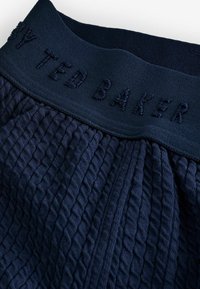 Granatowy elastyczny pasek w talii z wytłoczonym logo "Ted Baker", strukturalny wzór w zygzaki na tkaninie, tkany w zdobiony wzór.