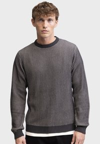 Grijze geribde trui met een gestructureerd design, ronde halslijn en contrasterende donkere manchetten en zoom. De stof lijkt gebreid en lichtgewicht.