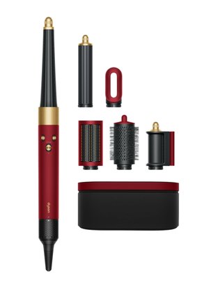 Roter und schwarzer Dyson-Hairstyler mit fünf abnehmbaren schwarzen und goldenen Aufsätzen und passendem Aufbewahrungskoffer auf weißem Hintergrund.