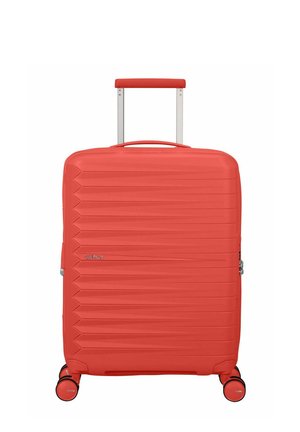 Valigia rigida rossa con manico retraibile e quattro ruote pivottanti, caratterizzata da scanalature orizzontali e chiusura laterale con cerniera.