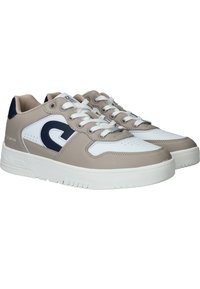 Zapatillas blancas y beige con parte superior texturizada, punta redonda, cuello acolchado y detalles de logotipo. Presentan cordones planos y suela de goma.