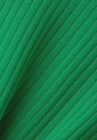 Ribbade gröna tyg som visar en texturerad yta med vertikala ränder, med en medeltjocklek och mjuk, vävd utseende.