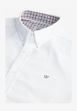 Witte katoenen shirt met een button-down kraag, voorzien van een geruit patroon in de nekvoering en een kleine marineblauwe kroonborduursel op de borst.