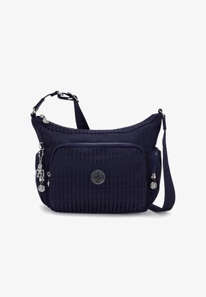 Sac à bandoulière bleu marine en tissu texturé avec une poche avant zippée, détail du logo et sangle réglable. Présente des accents en métal argenté.