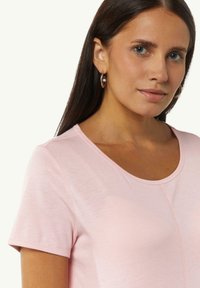 Lichtroze T-shirt met korte mouwen, een ronde hals en zichtbare naden, gemaakt van zachte, gladde stof.