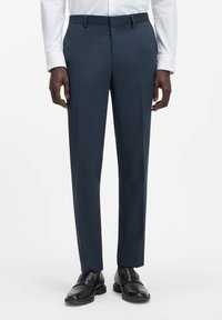 Pantaloni sartoriali blu navy realizzati in tessuto strutturato, con vestibilità dritta e davanti piatto, abbinati a mocassini in pelle nera.