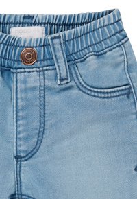 Lichtblauwe denim broek met een elastische tailleband, voorzien van een koperen knop, contrasterende stiksels en kleine voortassen.