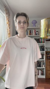 Růžové tričko s krátkým rukávem a kulatým výstřihem s vyšitým nápisem „PEGADOR“ v červené barvě. Měkká textura, volný střih a mírně oversized design.