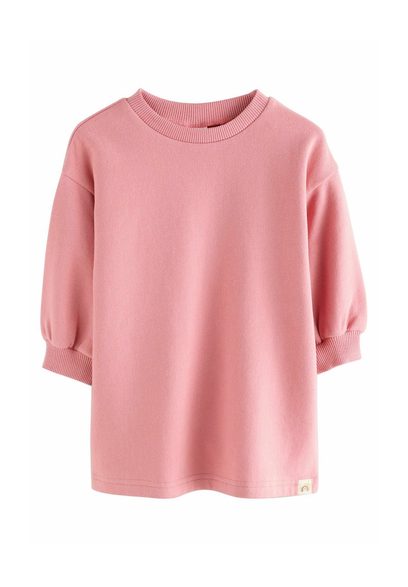 Rosa kurzärmeliger Pullover mit geripptem Rundhalsausschnitt und Bündchen, leicht gepufften Ärmeln und einem kleinen beigen Etikett mit einem Regenbogen-Icon am Saum.