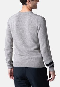 Maglione grigio chiaro con trama a coste, collo a giro, e maniche lunghe con strisce bianche e nere sui polsini. Design semplice.
