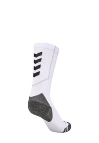 Witte sportsock met een ribbelstructuur, zwart chevronpatroon, gewatteerde grijze hiel en zwarte accenten nabij de tenen en bovenkant.