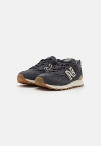 Adidași negri din nubuc cu accente cu imprimeu animal, talpă din cauciuc și întreținere albă contrastantă. Prezintă șireturi texturate și detalii cu logo.