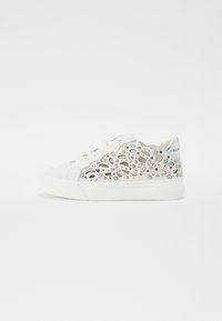 Hvit sneaker med utskårne blomsterdesign i blå og sølv aksenter. Myk tekstur med snøring, flat såle og avrundet tå.