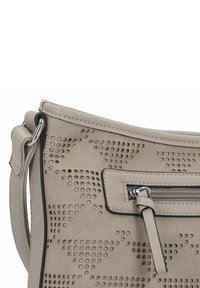 Beige Umhängetasche mit durchbrochenem Muster, glatter Textur, dünnem Schulterriemen und einer vorderen Reißverschlusstasche mit silberner Hardware und schwarzem Besatz.