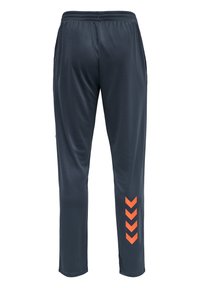 Pantalon de sport bleu marine en tissu lisse, avec une ceinture élastique et des accents en chevron orange sur la jambe gauche.