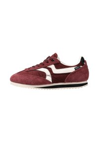 Zapatilla deportiva burdeos con parte superior de ante, diseño en zigzag blanco, acento negro en el talón y suela de goma texturizada. Cierre con cordones para un mejor ajuste.