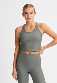 Olive green ribbed crop top with a rounded neckline, paired with matching high-waisted leggings. Smooth texture and fitted design.