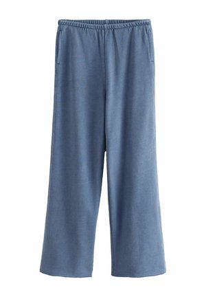 Pantalon de survêtement bleu clair, à jambes larges, fabriqué en tissu doux, avec une taille élastique et deux poches latérales. Texture lisse avec un design décontracté.