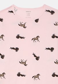 Lichtroze T-shirt met een herhalend patroon van galopperende en rollende paarden in donkerbruin en beige. Ronde hals, korte mouwen.