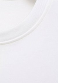 Bílý bavlněný tričko s límečkem s žebrovanou texturou, hladkým povrchem a kulatým výstřihem. Minimalistický design bez vzorů či akcentů.