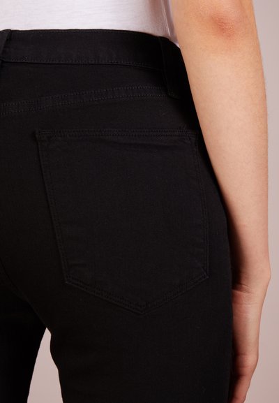 Svartrandiga jeans i svart denim med rak passform. De har en bakficka med minimal design och ren sömnad längs midjan.