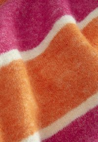Wielokolorowa dzianina z szerokimi paskami w kolorach różowym, pomarańczowym i białym. Tekstura wydaje się miękka i puszysta, co wskazuje na ciepło i komfort.