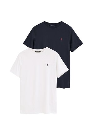 Dos camisetas lisas de cuello redondo, una blanca y una negra, cada una con un pequeño emblema de un golfista en el pecho izquierdo.