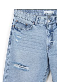 Jeans in denim blu chiaro con un design strappato, caratterizzati da strappi sfilacciati e accessori in tonalità rame. Stile classico a cinque tasche e chiusura con bottone.