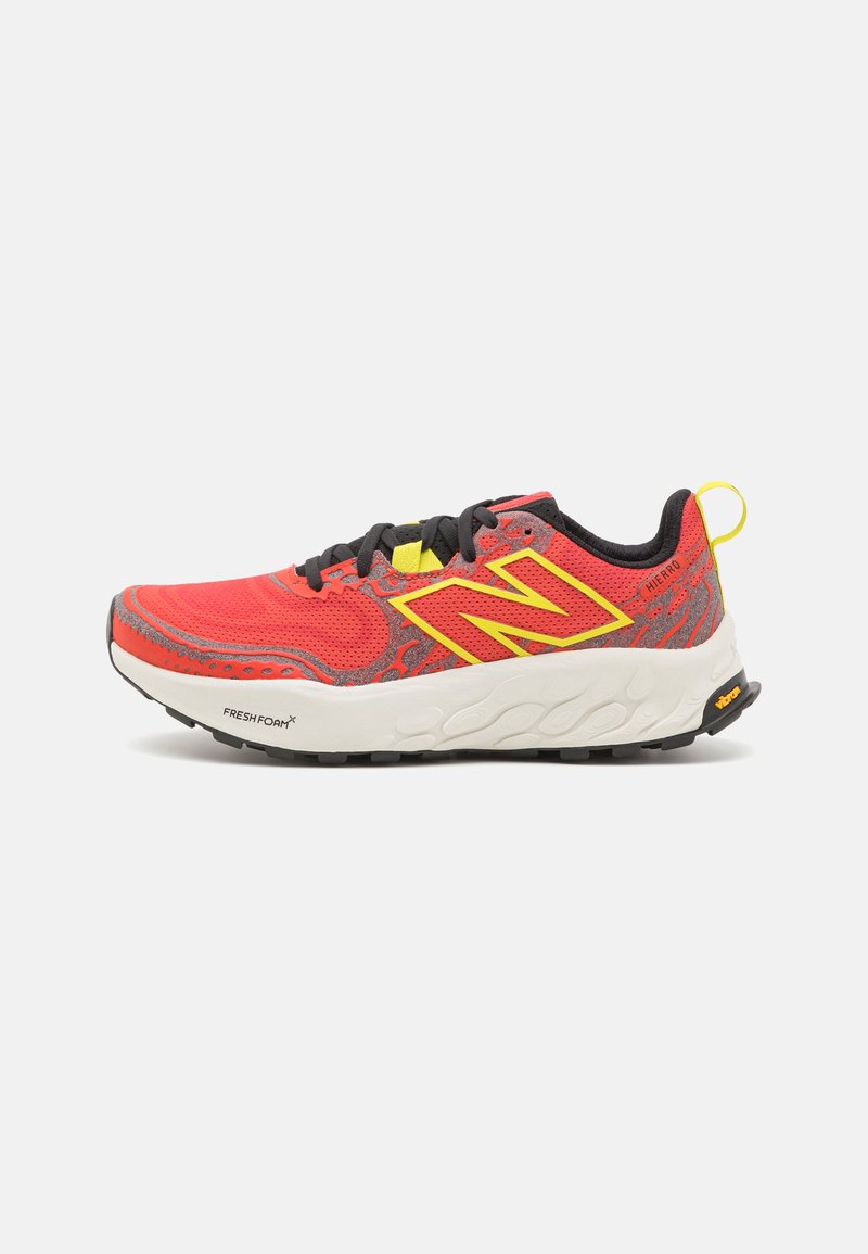Red running shoe with a mesh upper and black laces. Features yellow accents and grey patterns. Thick white midsole and rubber outsole.