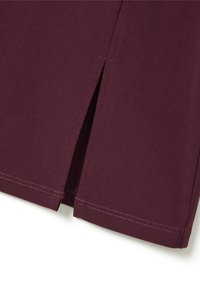 Tessuto bordeaux con orlo cucito, dotato di uno spacco laterale per facilitare i movimenti. Design semplice, texture liscia e finitura pulita.