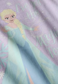Tissu sur le thème de la Reine des Neiges présentant Elsa avec des couleurs bleu clair et lavande, des motifs enneigés, et un texte disant "J'ai le toucher magique."