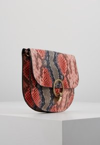 Borsa a tracolla con motivo in pelle di serpente nei toni del rosso, beige e blu navy, con un dettaglio in oro a forma di cerchio e chiusura a patta.