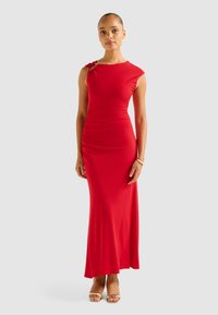 Red form-fitting maxi dress with a shoulder detail and ruching on one side. Features a smooth texture and a sleek silhouette.