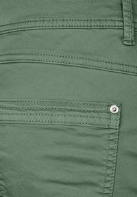Groene katoenen blendbroek met gestikte naden, voorzakken en een metalen knoopdetail. Soepele textuur en een getailleerd ontwerp.