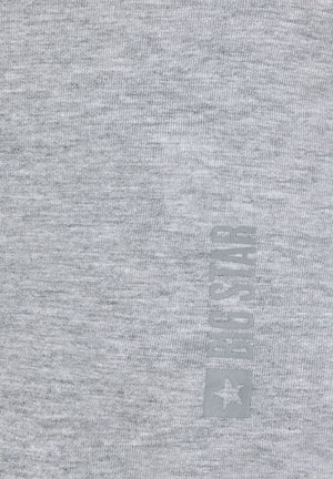 Helehall kangas õrna vertikaalse "FJG STAR" logoga ja tähega, mis on trükitud veidi tumedama halli tooniga.