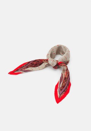 Zawiązany plisowany szalik z beżową bazą, czerwonymi grochami i wielokolorowymi wzorami z czerwonymi zakończeniami na białym tle.