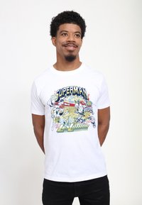 Hvid bomuld t-shirt med et farverigt grafik af Superman og Lex Luthor, med fede tekster og illustrationer i tegneseriestil.